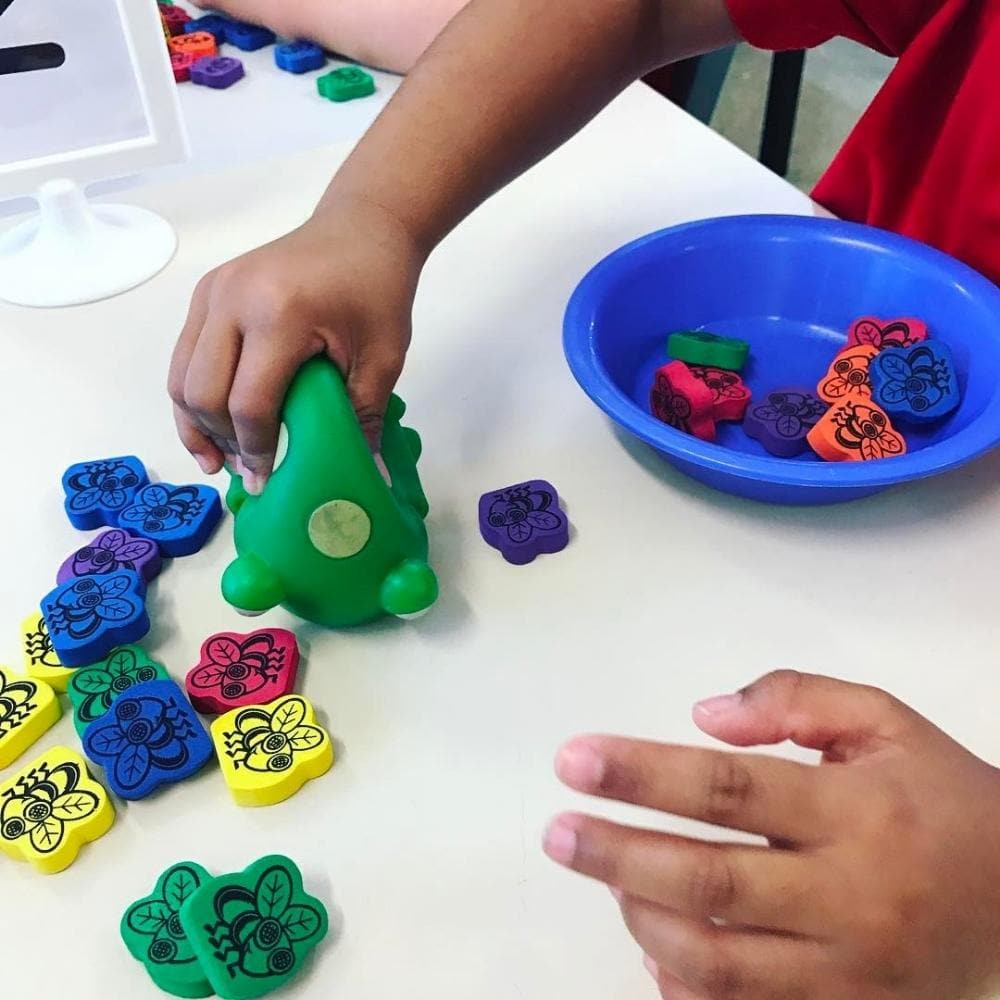 Froggy Feeding Fun Fine Motor Skills Game,In one mouthful, Froggy Feeding Fun Fine Motor Skills Game promotes proper handwriting position and teaches colours, counting and more! Squeeze the frog’s mouth to catch a treat in this unique fine motor skills game. Players roll the dice to determine the number and colour of flies to collect, then manipulate the durable plastic frog to collect them. The Froggy Feeding Fun Fine Motor Skills Game includes two frogs, 60 foam flies in six colours, two dice and Activity