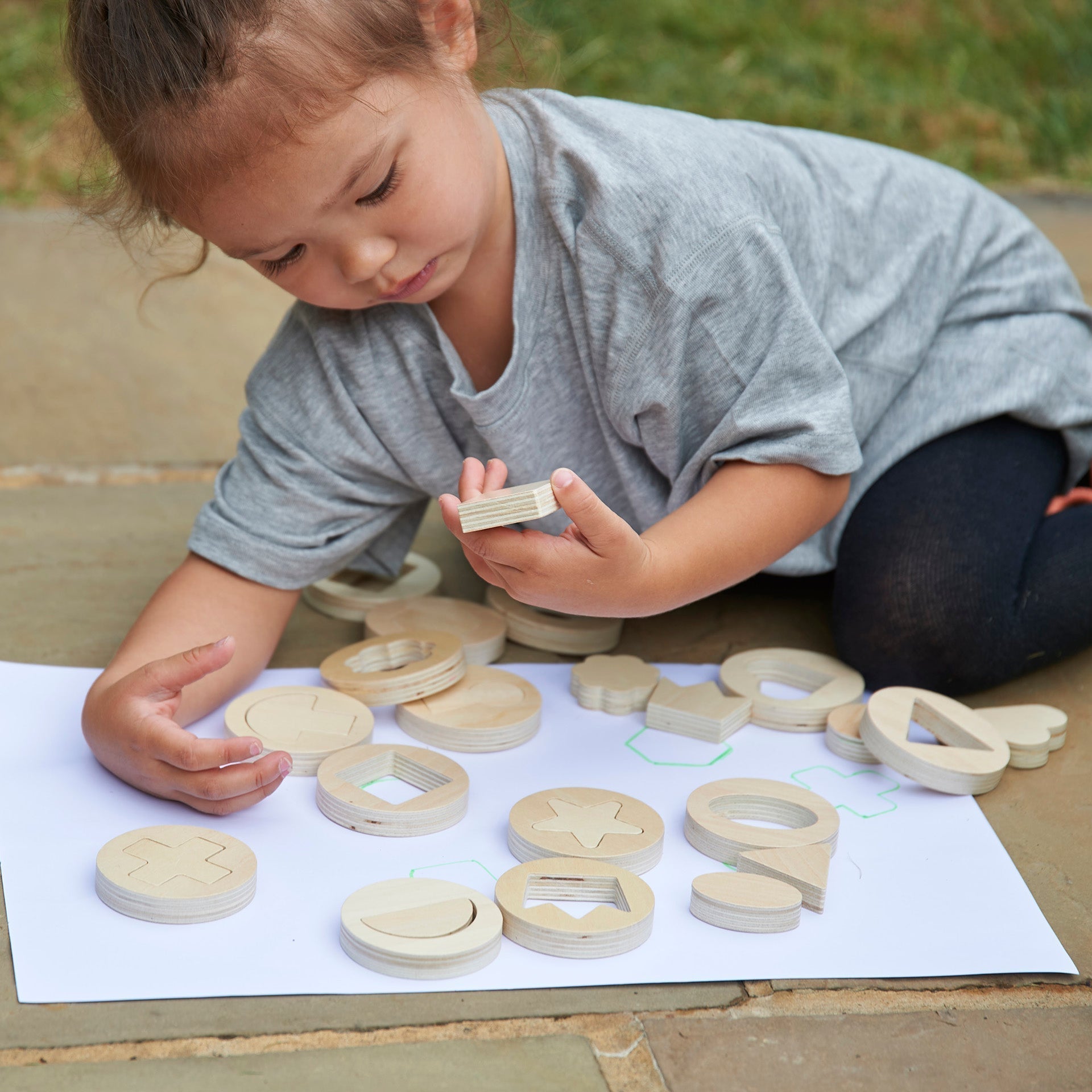 Inside Outside Wooden Shapes,The TickiT® Inside Outside Wooden Shapes set provides exciting and stimulating fun for your child to explore shape sorting and puzzle solving. This set is designed to enhance fine motor skills, hand-eye coordination, and early mathematical understanding through interactive play. Inside Outside Wooden Shapes Features Smooth and Tactile Design: Each of the 14 wooden discs is smooth and tactile, perfect for small hands to handle. The chunky, 1.2cm thick removable shapes are easy fo