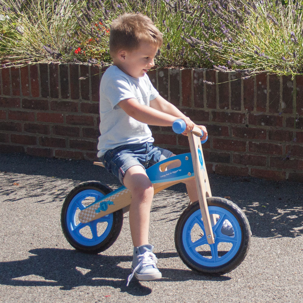 My First Balance Bike Blue,Introduce your little one to the joy of mobility with My First Balance Bike in Blue. Crafted from sturdy wood and designed with young riders in mind, this balance bike is the perfect way for toddlers to kick-start their journey towards two-wheeled adventures. Featuring a sleek blue design, this wooden balance bike is as stylish as it is functional. With its padded and adjustable seat, solid tyres, and easy-to-grip handlebars, it offers young riders a comfortable and secure riding 