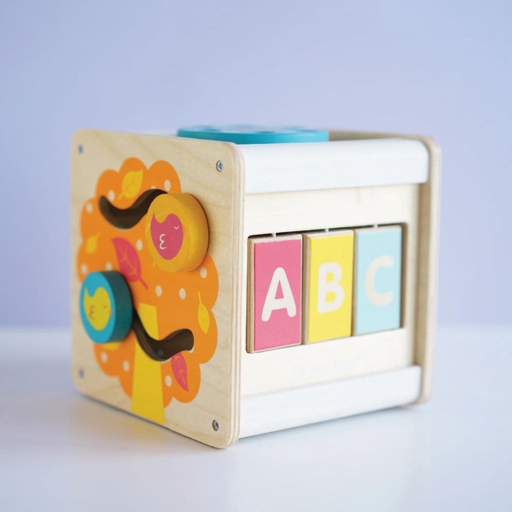 Petit Activity Cube,The Petit Activity Cube is a delightful and versatile wooden toy designed to engage and entertain toddlers with its array of stimulating activities. Here's why it's the perfect choice for curious little minds: Multi-functional compact design: This petite activity cube packs a punch with its variety of activities, including a door to open, spinning wheel, ABC/123 flaps, xylophone, spinning gears in a flower motif, and two birds sliding across an autumn tree. Each side offers a new and exc