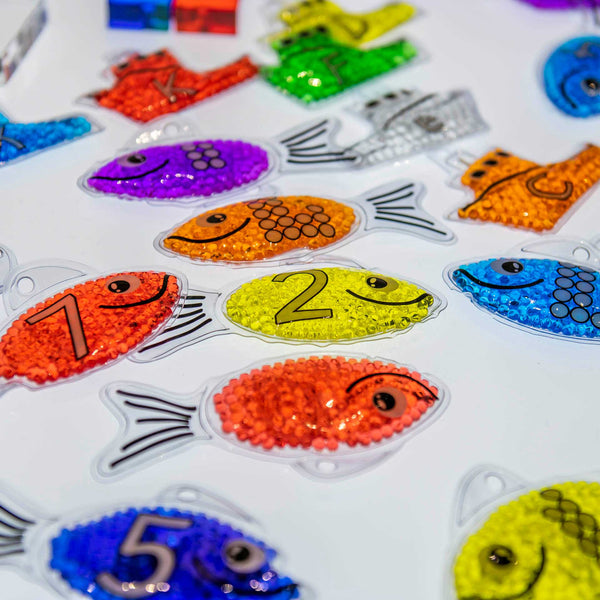 Rainbow Gel Number Fish,Vibrantly rainbow coloured Rainbow Gel Number Fish with numbers 0-20 on one side and their corresponding dots on the other. The Rainbow Gel Number Fish are Ideal for learning to count, to associate numbers with quantities, for colour recognition and for sensory play. The tactile squashy Rainbow Gel Number Fish contain gel-like beads in 7 crystal clear rainbow colours, with a loop at the top for hanging on a string or with pegs. The translucent colours contained within the Rainbow Gel