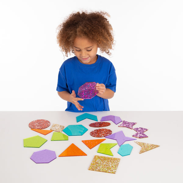 Rainbow Glitter Shapes,Our TickiT Rainbow Glitter Shapes set contains a range of dazzling acrylic shapes in the 7 colours of the rainbow. Your child will be captivated as they watch how the shapes sparkle in the light and will be keen to explore the different configurations.Each colour includes 3 styles of a polygon and both irregular and regular shapes. The Rainbow Glitter Shapes are a fascinating and fun way to understand basic geometry and create interesting patterns and sequences. Ideal to use with a li