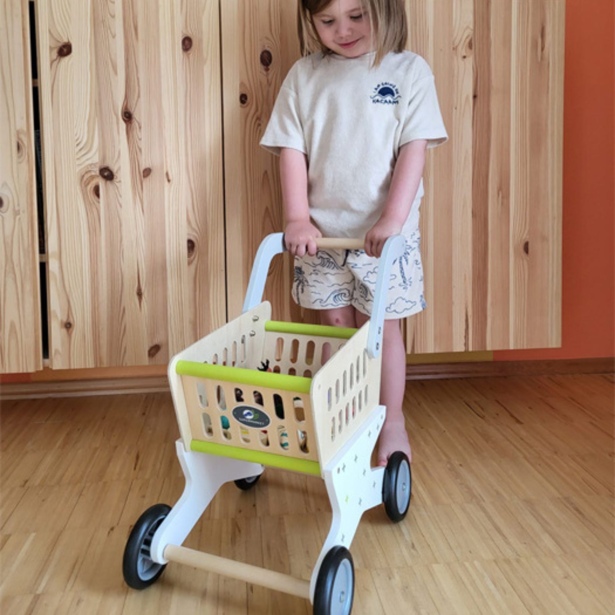 Wooden Shopping Trolley,This delightful shopping trolley provides ample capacity for small-scale grocery stores. With ergonomically formed handles and rubber-coated wheels, children can effortlessly manoeuvre it through the aisles. An aperture in the basket ensures kids can easily monitor their "purchases," making it perfect for pretend play. Features: Ergonomic Design: Ergonomically formed handles for easy handling. Smooth Mobility: Rubber-coated wheels for smooth pushing. Visible Basket: Aperture in the b